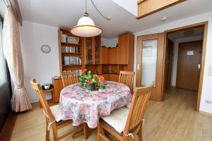 ein Esszimmer mit einem Tisch mit Blumen darauf in der Unterkunft Haus "Jan am Strand" Appartement JAN504 in Döse