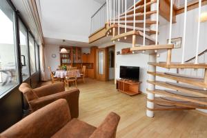 a living room with a spiral staircase and a dining room at Haus "Jan am Strand" Appartement JAN504 in Döse