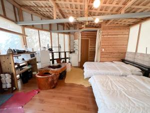 um quarto com 2 camas num chalé de madeira em 貸別荘・グランピングひめしゃら em Kirishima