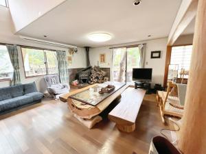 uma sala de estar com uma mesa e um sofá em 貸別荘・グランピングひめしゃら em Kirishima