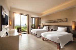 三亞的住宿－三亚海棠湾万达嘉华度假酒店，酒店客房设有两张床和电视。