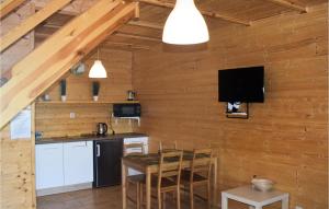 シャノジェンティにある2 Bedroom Cozy Home In Sianozetyの木製の壁にテレビとテーブル付きのキッチンが備わります。