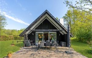 una casa con techo negro y sillas en un patio en Awesome Home In Toftlund With 3 Bedrooms, Sauna And Wifi, en Vestergård