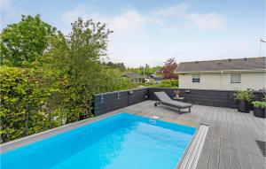 a swimming pool on the deck of a house at Nice Home In Haderslev With 2 Bedrooms, Wifi And Outdoor Swimming Pool in Haderslev