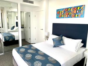 a bedroom with a large bed with a mirror at Serenity Deja Blue - at Darwin Waterfront in Darwin +16 photos