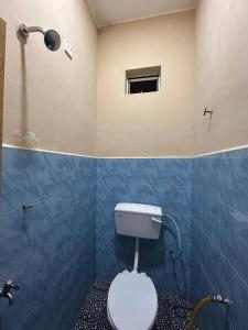 La salle de bains est pourvue de toilettes, d'une fenêtre et d'une douche. dans l'établissement Mahasa Penarik Homestay, à Kampong Ru Sepuloh