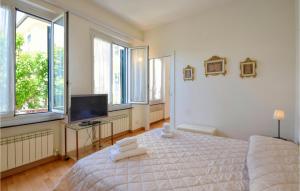 een slaapkamer met een bed, een tv en ramen bij Lovely Apartment In Recco With Kitchen in Recco