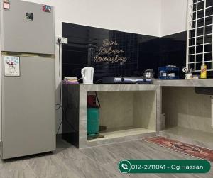 eine Küche mit einem Kühlschrank und einer Theke in der Unterkunft Homestay Seri Kelana Kuala Terengganu 