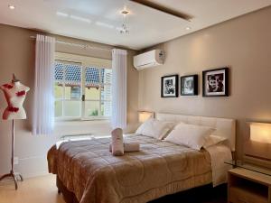 a bedroom with a bed and a window at Cobertura Duplex de Cinema 3dorm by Achei Gramado in Gramado