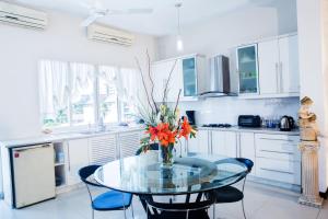 una cocina con una mesa de cristal con un jarrón de flores en Whitehouse Residencies, en Colombo