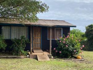 a blue house with a door and some flowers at Casa familiar en sector residencial "HARE TOKE" in Hanga Roa