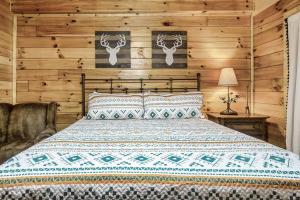 a bedroom with a bed in a room with wooden walls at Cabin with New Hot Tub, Near Dollywood .2BD.2BA.Sleeps6.BBQ in Sevierville