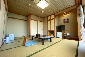 a living room with a table and a chair at Tango Onsen Hashiudosou in Kyotango