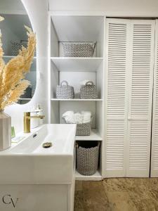 a white bathroom with a sink and a mirror at Casa Loba Suite 4 with private pool in Rincon