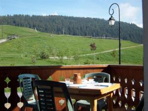 a table and chairs on a balcony with a view of a hill at Chalet Crest-Voland, 6 pièces, 8 personnes - FR-1-733-2 in Crest-Voland
