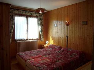a bedroom with a bed with a red blanket and a window at Chalet Crest-Voland, 6 pièces, 8 personnes - FR-1-733-2 in Crest-Voland