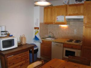 eine kleine Küche mit Mikrowelle und Herd in der Unterkunft Appartement Crest-Voland, 3 pièces, 6 personnes - FR-1-733-15 in Crest-Voland