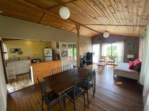 a dining room and living room with a table and chairs at Casa familiar en sector residencial "HARE TOKE" in Hanga Roa