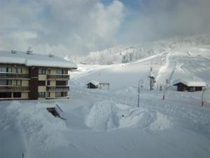 a ski lodge with a pile of snow next to a ski slope at Appartement Crest-Voland, 2 pièces, 6 personnes - FR-1-733-6 in Crest-Voland