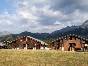a group of buildings with mountains in the background at Duplex cosy 3 pièces pour 6 pers. à Crest-Voland, balcon, proche des pistes et commerces - FR-1-733-58 in Crest-Voland