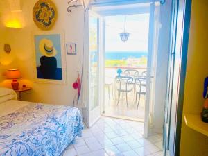 - une chambre avec un lit et une porte ouverte sur une terrasse dans l'établissement Scala Fenicia 14 by CapriRooms, à Capri