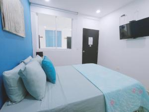 1 dormitorio con 1 cama con almohadas y TV en Hotel Sunset Beach en Cartagena de Indias