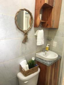 a bathroom with a sink and a toilet and a mirror at Beautiful sea front apartment in Paraíso