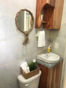 a bathroom with a sink and a toilet and a mirror at Beautiful sea front apartment in Paraíso +7 photos