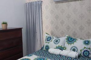 a bedroom with a bed with blue and white pillows at Beautiful sea front apartment in Paraíso