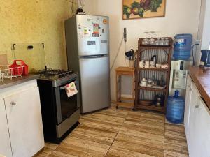 uma cozinha com um frigorífico e um fogão em Casa familiar en sector residencial "HARE TOKE" em Hanga Roa