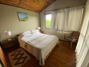 Un dormitorio con una cama grande y una ventana en Casa familiar en sector residencial "HARE TOKE", en Hanga Roa