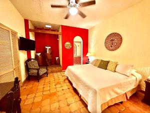 - une chambre avec un lit et un mur rouge dans l'établissement La Villa del Ensueno Boutique Hotel, à Guadalajara