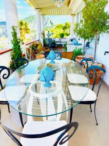 a glass table and chairs on a patio at Scala Fenicia 14 by CapriRooms in Capri