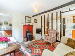 a living room with a couch and a fireplace at Oaklawn Cottage in Eye