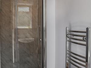 a shower with a glass door in a bathroom at Sandy Paws in Gorleston-on-Sea