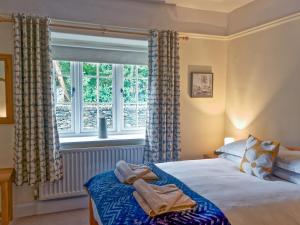 a bedroom with a bed and a large window at Granton Lodge in Far Sawrey