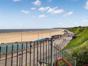 a view of a beach and the ocean from a balcony at Sandy Paws in Gorleston-on-Sea