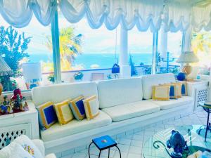 a living room with a white couch with colorful pillows at Scala Fenicia 14 by CapriRooms in Capri