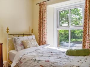 Poplar Farm Cottage في Westbury-sub-Mendip: غرفة نوم بسرير ونافذة