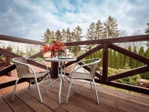 einen Tisch und zwei Stühle auf einer Holzterrasse in der Unterkunft Comfortable holiday villa in the countryside, 8 bedrooms, 9 bathrooms, Be czna 