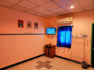 a room with a room with a tv on a wall at Ingpha Room For Rent in Satun