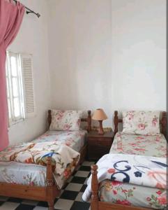 1 dormitorio con 2 camas individuales y lámpara en My house en Rabat