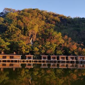 a row of houses on a bridge over a river at Tugawe Cove Resort in Colongcocon