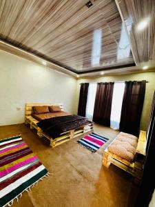 a bedroom with a bed and two rugs in a room at Orgventure Resorts Skardu in Skardu