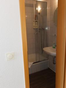 ein Bad mit einer Dusche und einem Waschbecken in der Unterkunft Pension Markt Neustrelitz in Neustrelitz