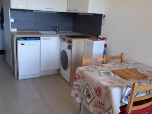 a kitchen with a table and a washing machine at Studio Crest-Voland, 1 pièce, 4 personnes - FR-1-733-111 in Crest-Voland
