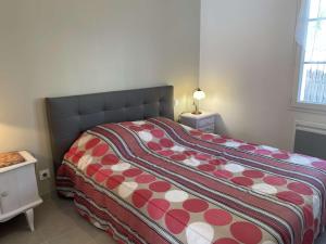 1 dormitorio con 1 cama con edredón rojo y blanco en Maison L'Épine, 2 pièces, 2 personnes - FR-1-224B-190, en LʼÉpine