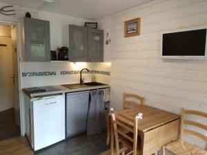 a kitchen with a sink and a table and a tv at Studio cosy avec terrasse, équipements complets, parking et casier à skis - Crest-Voland - FR-1-733-118 in Crest-Voland