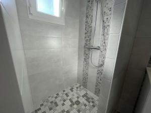 y baño con ducha y suelo de baldosa. en Maison L'Épine, 2 pièces, 2 personnes - FR-1-224B-190, en LʼÉpine