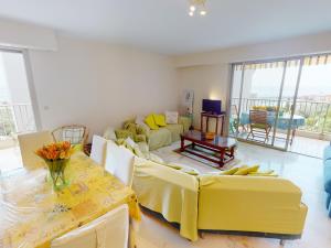 a living room with yellow furniture and a table at Grand 3P à Menton avec terrasses et parkings - FR-1-196-331 in Menton